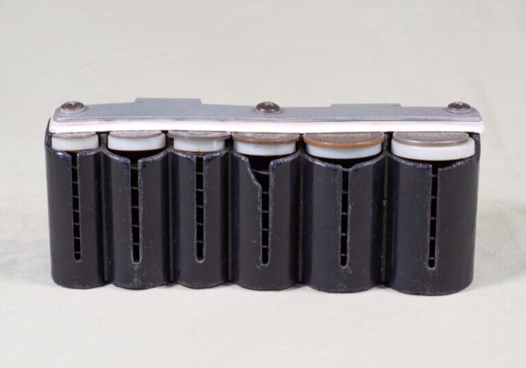 A spring loaded holder for coins used by conductors and conductresses in their ticket bags.