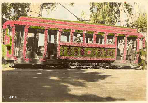 Hand coloured photograph of tram No. 23 decorated for the 1938 Floral Festival.